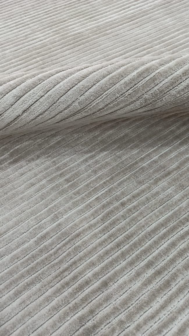 Pale grey rug with a fine ribbed, carved surface
