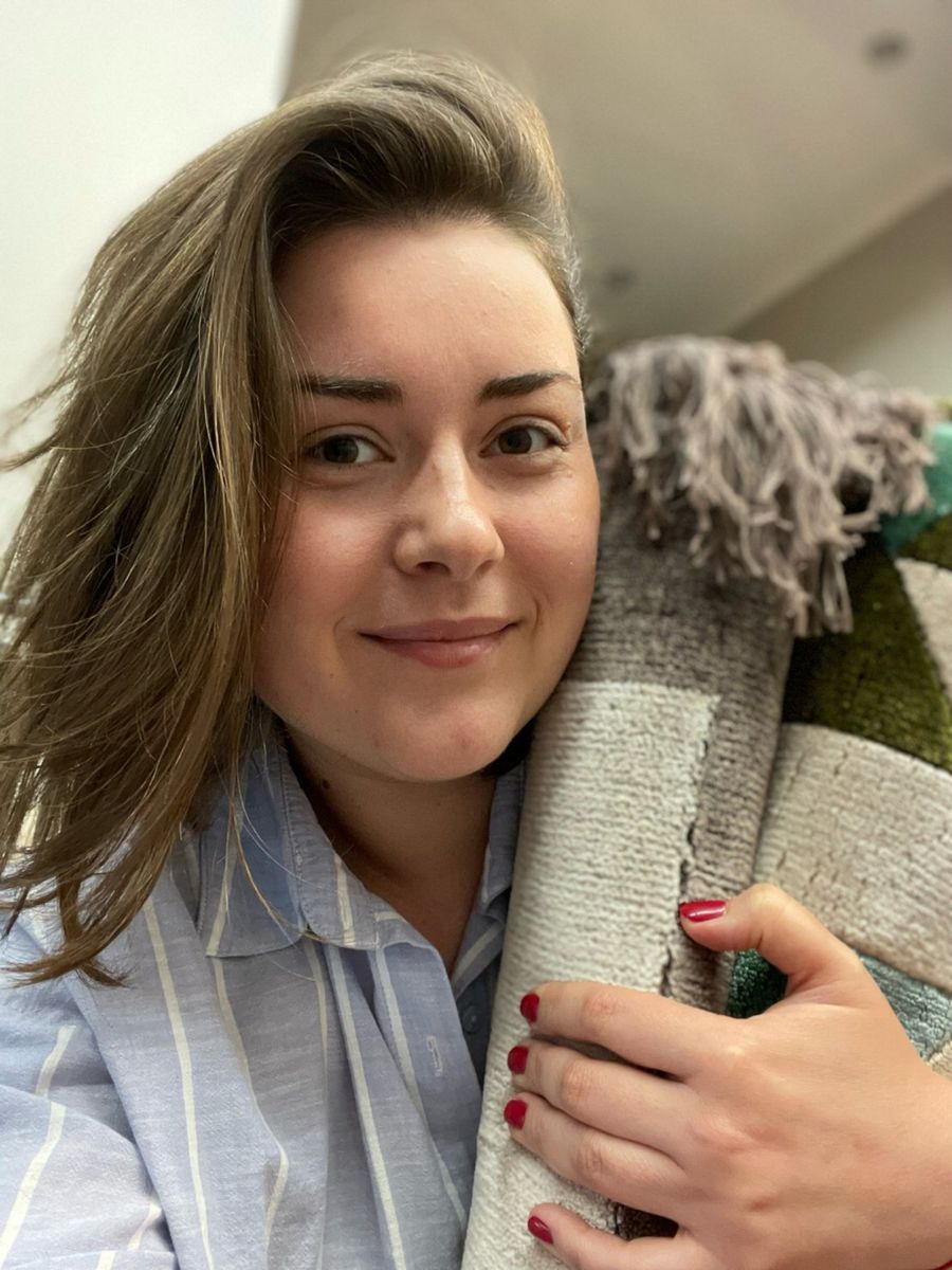 Yulia Salata holding a rolled rug