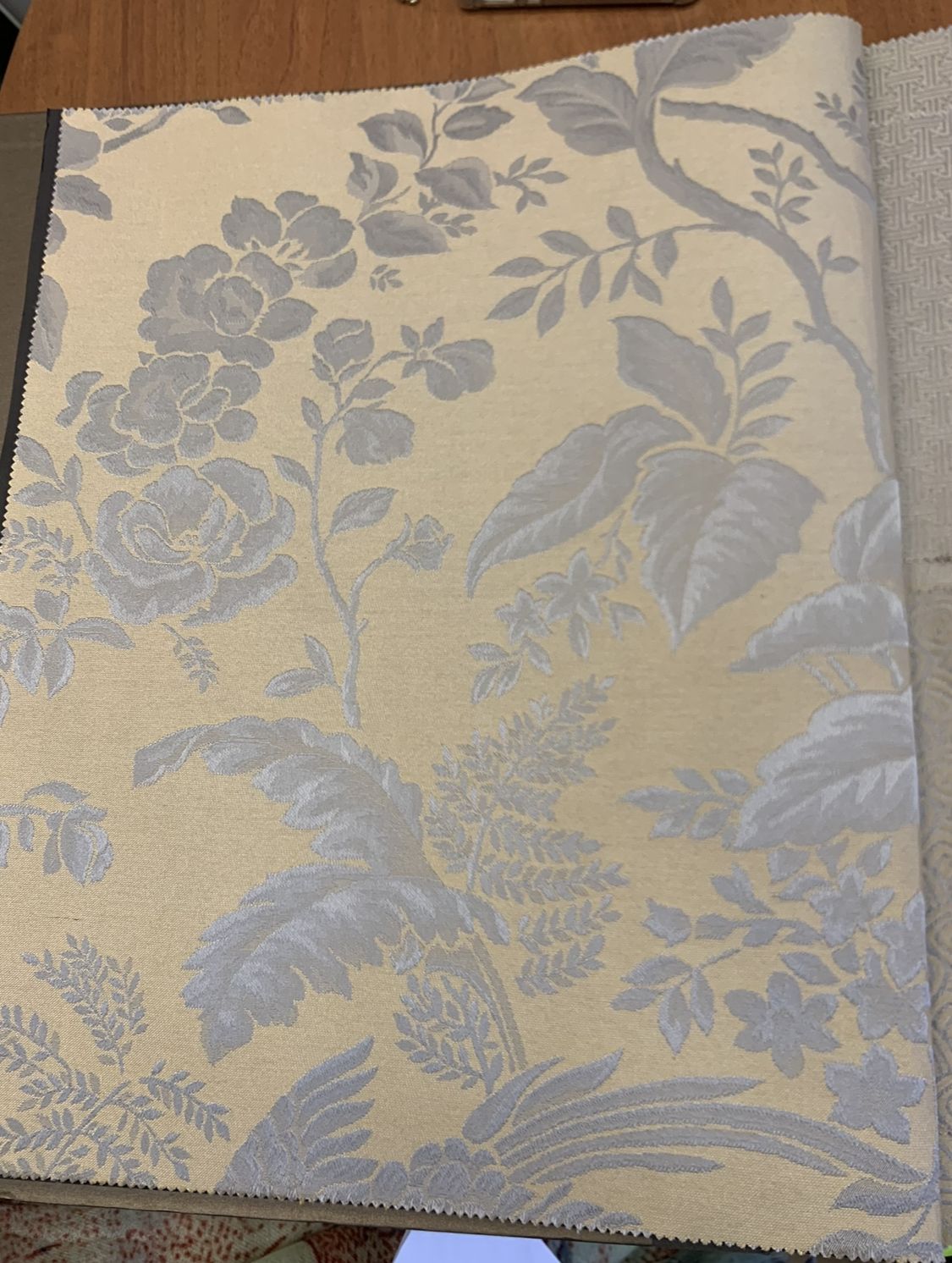 Silk wallpaper sample with a floral pattern in grey on cream