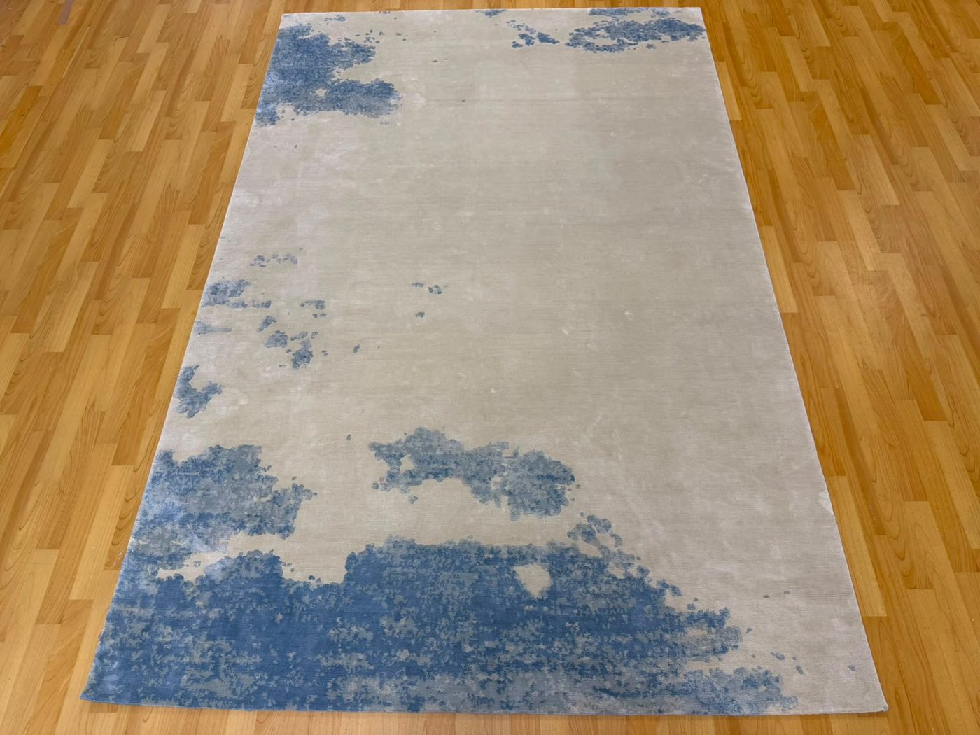 Finished ivory silk rug with blue cloud-like shapes