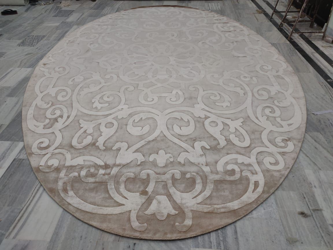 Oval rug with a raised scroll pattern in two tones of beige