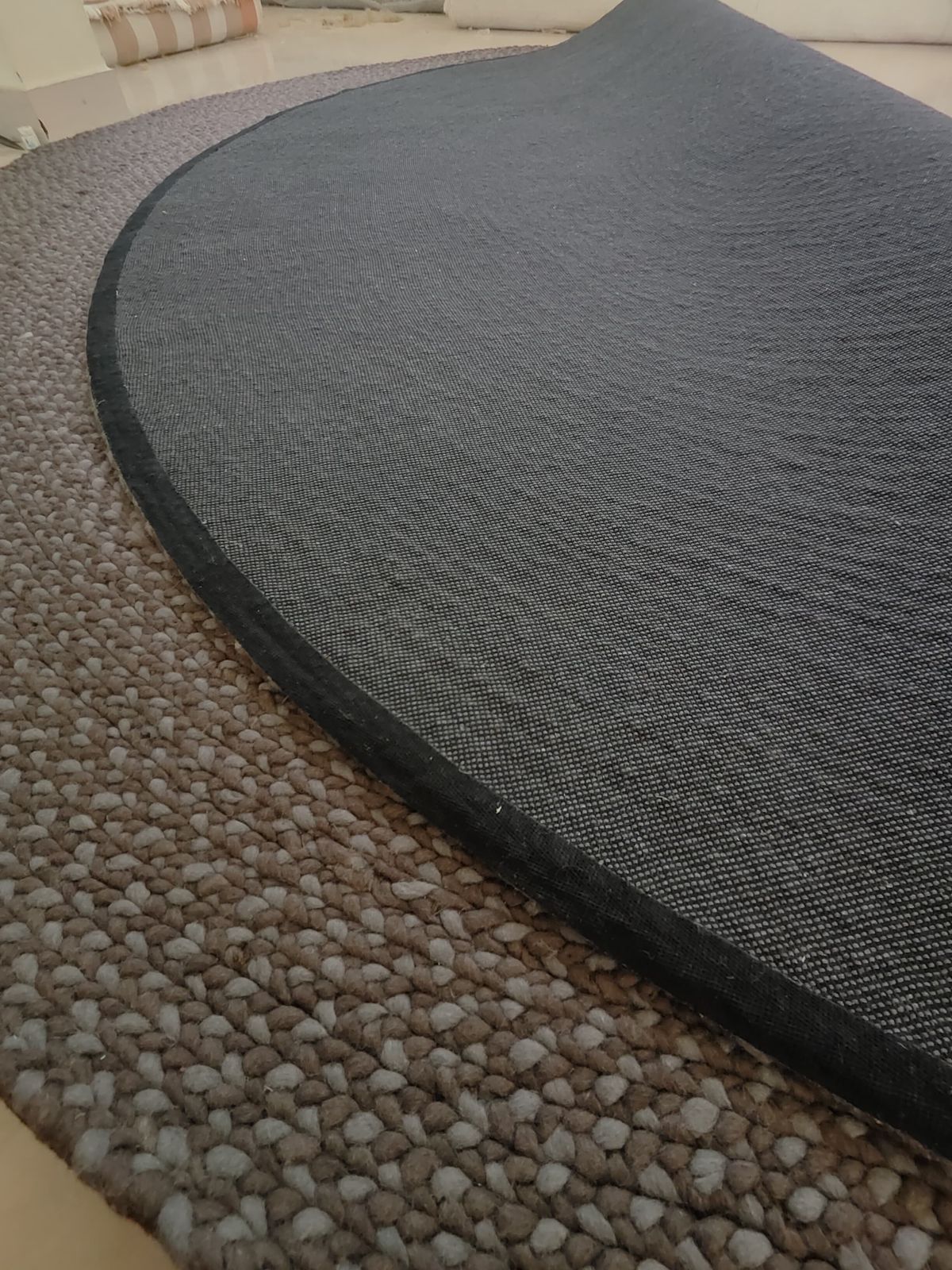 Round rug turned over to show the back and the bound edge